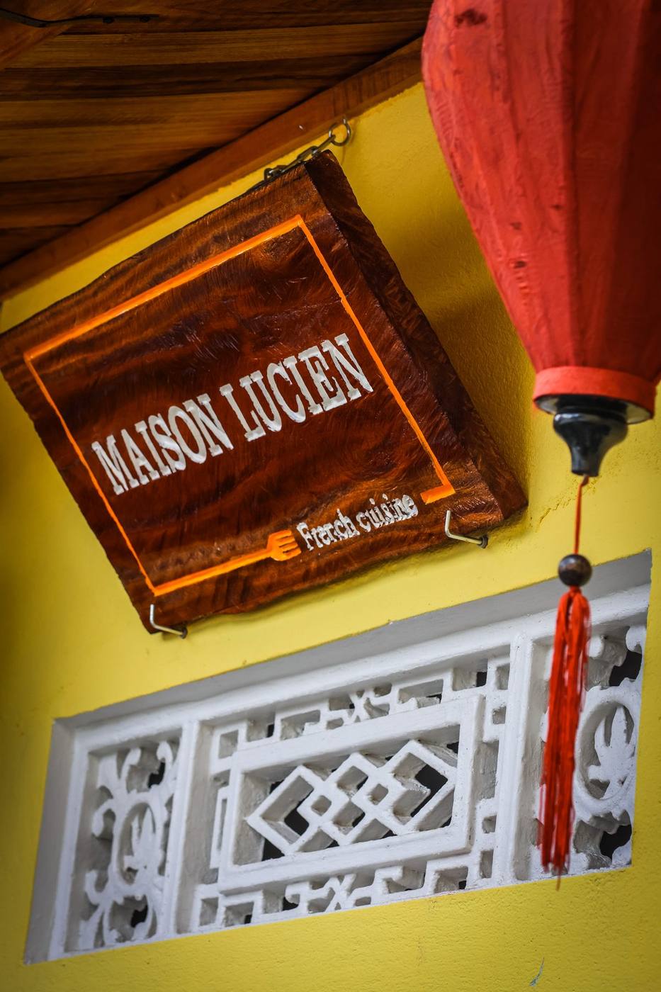Maison Lucien wooden sign with French cuisine text and Hội An red lantern