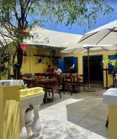 Maison Lucien bistrot terrace in Hội An old town, yellow walls, blue shutters